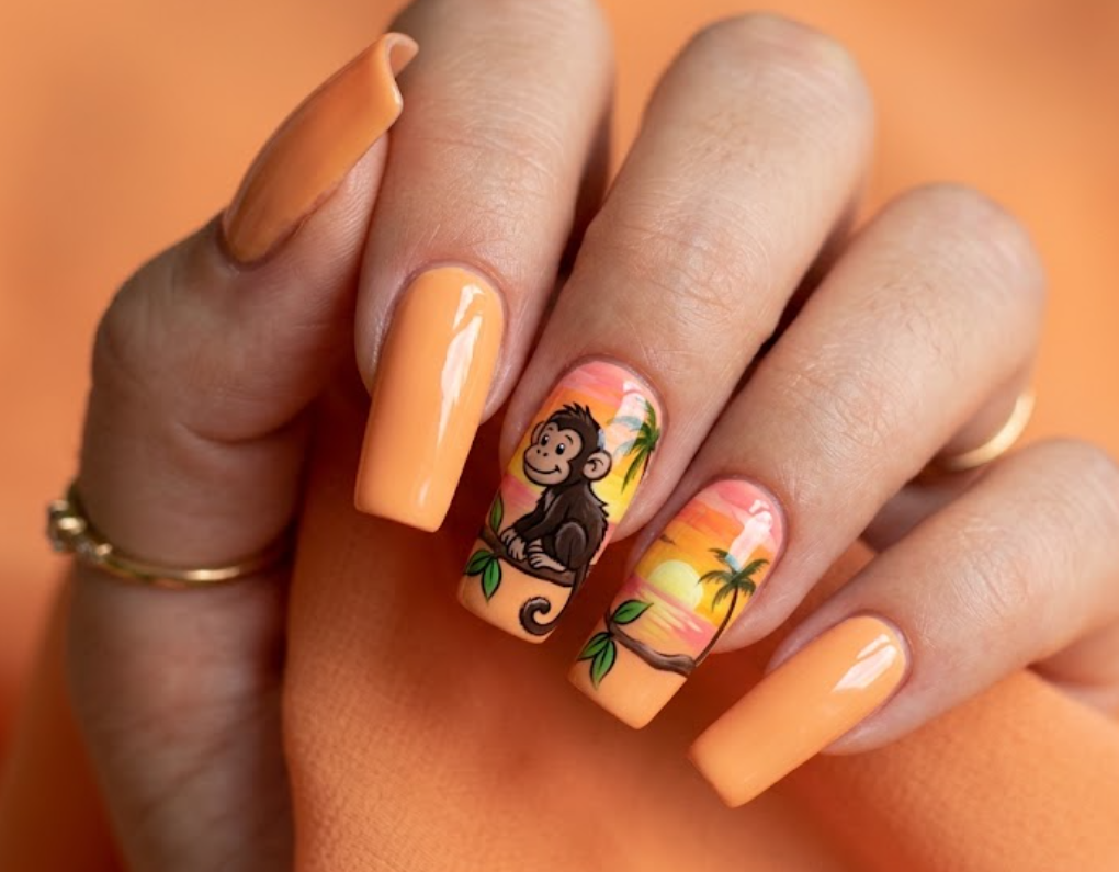 In this image, orange nails with a cartoon monkey and sunset