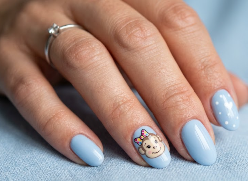 In this image, powder blue nails with a cartoon monkey wearing a bow