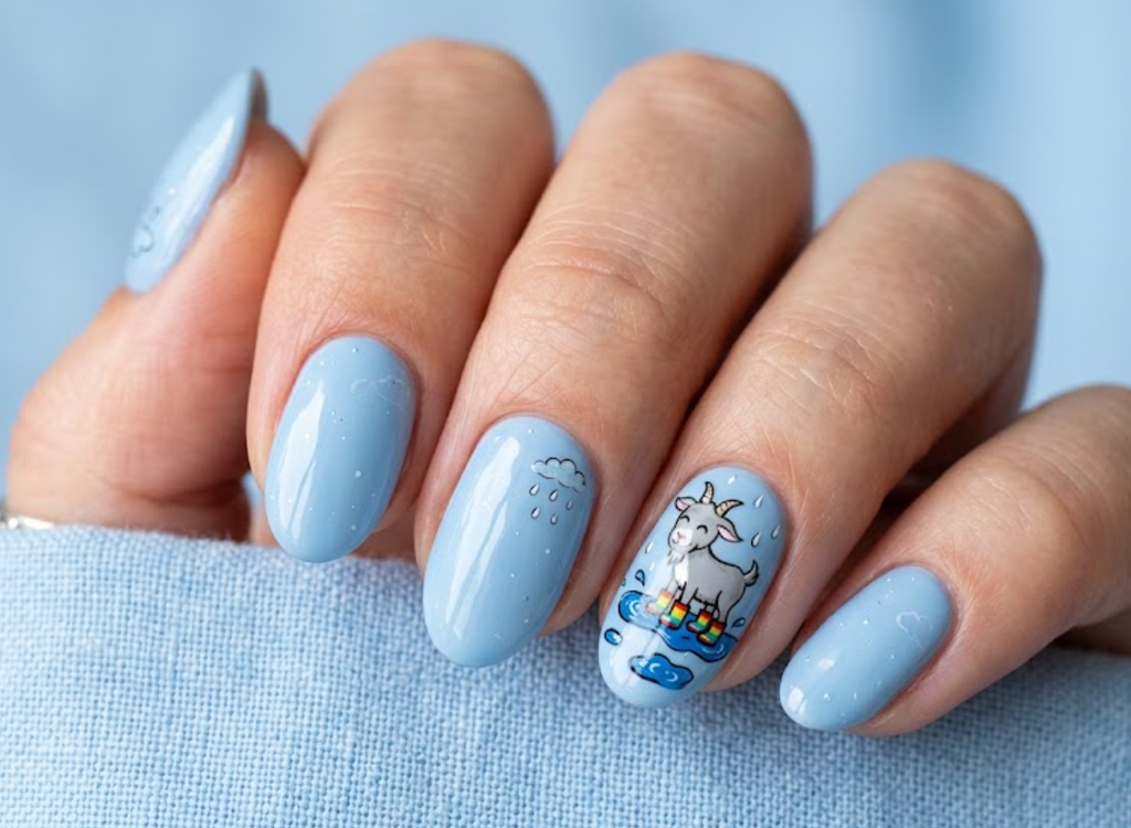 In this image, powder blue nails with a cartoon goat wearing rain boots