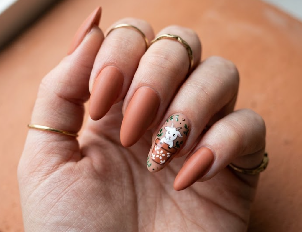 In this image, terracotta nails with a cartoon goat inside a flower pot