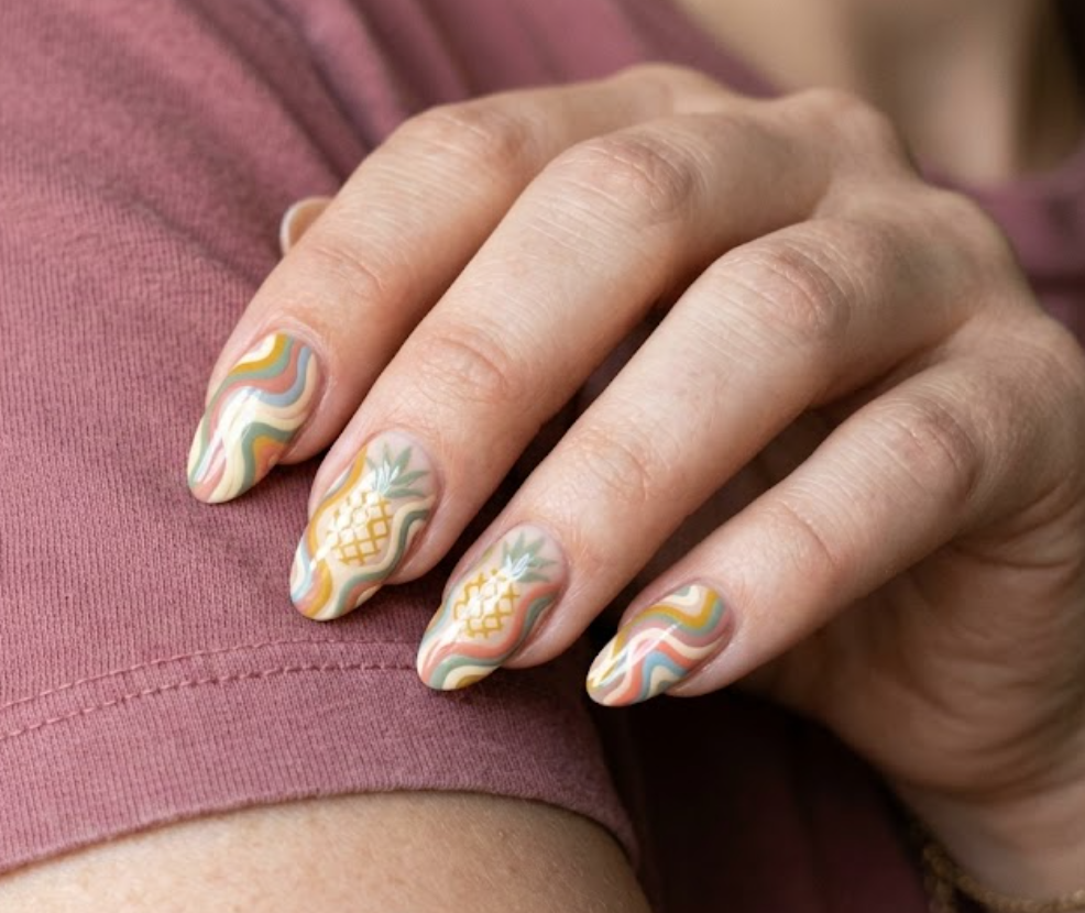 in this image, a hand in a rose shirt displays 70s pastel swirls integrating a hidden pineapple.