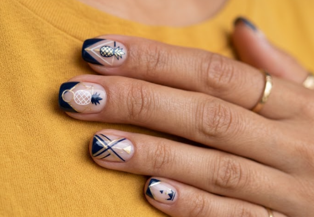 in this image, a hand in a mustard shirt displays negative space geometric shapes with a pineapple.