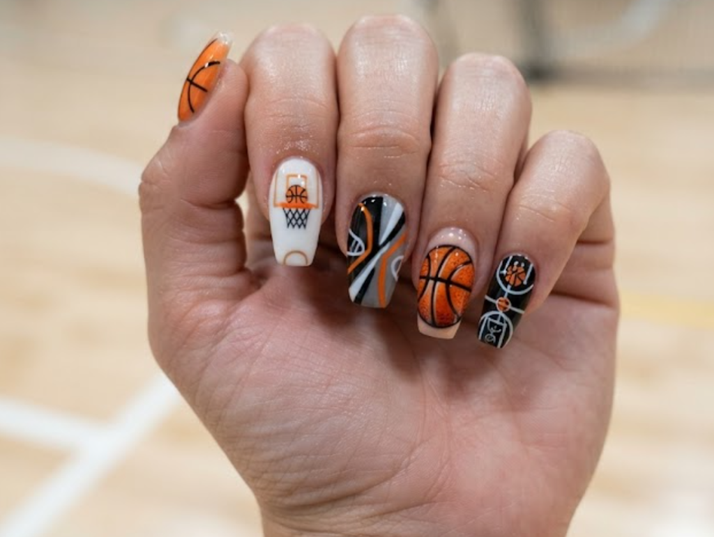 In this image, orange basketball nails with basketball court lines and sporty geometric patterns.