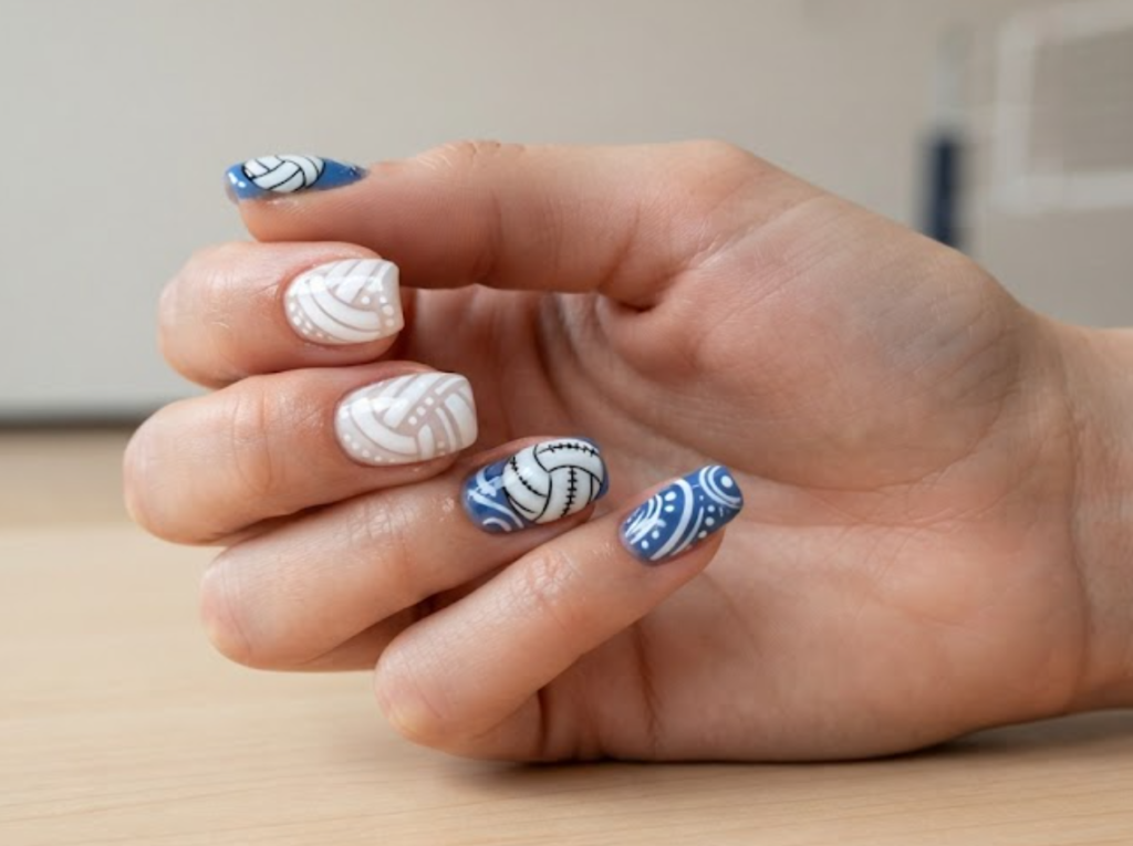 In this image, volleyball nails with white volleyballs, curved lines, and sporty swirls.